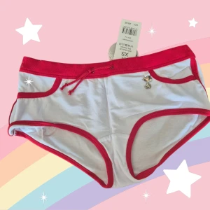 Snoopy hipster med röd kant XS - Supergulliga vita hipstertrosor med röda kanter och snörning i midjan. Framtill finns en liten Snoopy-charm och baktill ett tryck med Snoopy i rött. Mjukt material i 95% bomull och 5% elastan för skön passform. Perfekt för dig som gillar söta detaljer och tecknade motiv. Är aldrig använd, kommer från ett konkurslager. Se även mina andra auktioner. Bundlerabatt på 20% vid flerköp.
