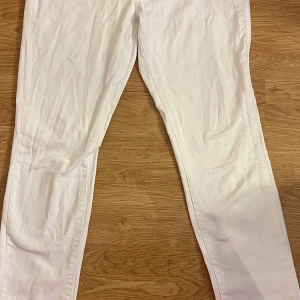 Vita skinny jeans med dragkedjedetalj - Snygga vita jeans med smal passform och dragkedjedetalj vid fickan. Klassisk femficksmodell i stretchigt jeanstyg som sitter tajt hela vägen ner. Perfekta för dig som gillar en clean och fräsch look.