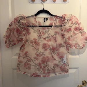 Blommig topp - Blommig transparent topp med puffärmar från vero Moda. Stolen xs men funkar nog på xs-m. Aldrig använd!