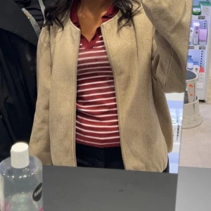 Beige bomberjacka från Freequent - Säljer en stilren beige bomberjacka från Freequent i storlek medium. Jackan har en enkel design med dragkedja framtill och är tillverkad i ett mjukt ullmaterial. Endast använd en gång köpte för 600kr!