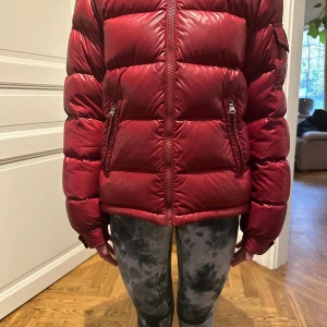 Dunjacka från Moncler - Mörkröd Vinterjacka från Moncler.Köpt från Vestiaire Collective. Funkar för både Killar och Tjejer. Bra skicka, otroligt bra kvalitet!! Står Storlek 12 i men passar mig som är 160cm och 14 år.Skriv om du vill ha fler bilder eller om du har några frågor☺️. Skulle möjligtvis kunna sänka priset lite.