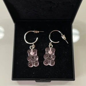 Rosa björngodis örhängen - Supergulliga örhängen med genomskinliga rosa björngodis-hängen på silvriga hoops. Perfekta för dig som vill ha en lekfull och söt detalj till din stil. Lätta att bära och ger en unik touch till din outfit. Bara testade då jag fick de som present💗