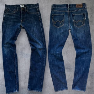 Edwin japan jeans - Snygga Edwin ED-80 jeans i slim fit med klassisk femficksdesign och coola kontrastsömmar. Färgen är mörkblå med lätt tvättad look och detaljerade bakfickor. Perfekt passform för dig som gillar smalare jeans.
