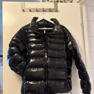 Svart pufferjacka från Colmar ”ladies down jacket” - Säljer en svart, glansig pufferjacka från Colmar Originals. Kom med bud! Jag säljer den för att jag beställde fel modell + fel storlek 🥰. Jackan är köpt för 5999k och knappt använd därför är priset som det är. Inga defekter eller skador! 