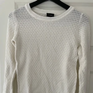 Vit stickad tröja från Vila XS - Snygg vit stickad tröja från Vila i storlek XS. Tröjan har ett diskret hålmönster, rund halsringning och långa ärmar. 🥰