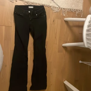Svarta bootcut jeans från Perfect Jeans - Svarta jeans från Perfect Jeans med bootcut passform. Klassisk femficksmodell med snygga bakfickor med lock och silverfärgade knappar. Jeansen har normal midja och är tillverkade i ett stretchigt denimtyg för skön passform.