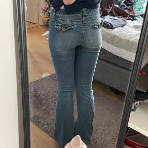 Lågmidjade jeans - Skit snygga lågmidjade blå jeans med coola fickor bak! Passar mig som brukar ha S och är 171, kan passa någon lite längre också! De är lite slitna längst ner men det syns knappt! Står W27 L35 på lappen!
