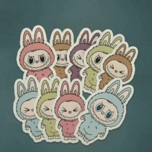 Dekalset med kaninmonster-figurer labubu - Färgglada klistermärken med unika kaninmonster-figurer i olika färger. Perfekt för att dekorera laptops, surfplattor eller andra elektronikprylar. Klistermärkena ser ut att vara i nyskick utan synligt slitage eller defekter.