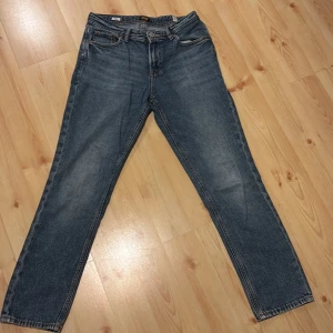 Blå jeans från Jack & Jones, stl 164 - Klassiska blå jeans från Jack & Jones i rak modell. Jeansen har fem fickor, snygga kontrastsömmar och en läderpatch med logga bak i midjan. Tillverkade i slitstarkt denimtyg som passar perfekt till vardagslooken. Obs slitmärken på sista bilden annars bra kvalité