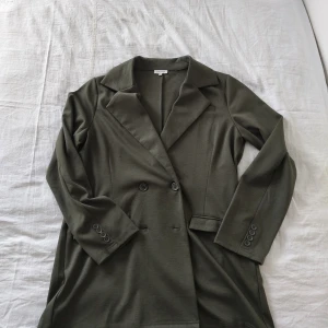 Kavaj från bubbleroom - Kavaj från Bubbleroom i storlek L. Färgen är mörkgrön/olivgrön. Passar perfekt både till vardags och fest, lätt att styla över en topp eller klänning. Använd få gånger och i fint skick. Ny pris 600