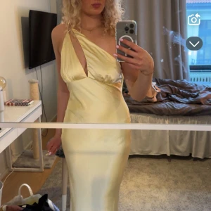 Balklänning - Elegant ljusgul långklänning i siden med en stilren oneshoulder-design. Köpt på hemsidan Bille J! På hemsidan kostar den 841kr men med tull 1300kr då den kommer från Australien. Säljer den pågrund av inte min stil!🩷klänningen finns inte kvar på hemsidan längre!🩷Använd 1 gång