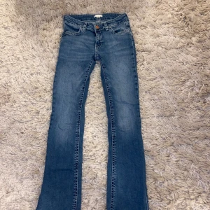 Blå bootcut jeans från Gina Tricot - Snygga blå jeans med bootcut passform och vita kontrastsömmar på bakfickorna. Storlek 164.