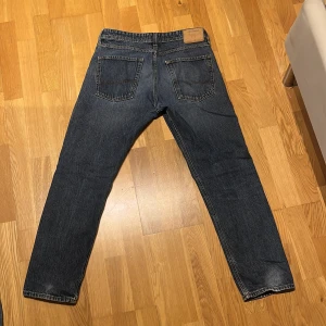 Jack & Jones Loose Chris - Säljer ett par blå jeans från Jack & Jones, modell Loose Chris. Jeansen har en loose passform, klassisk femficksdesign och är tillverkade i denim med snygg tvätt. Perfekta för dig som gillar en avslappnad stil men det finns en del slitningar.