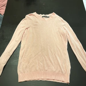 Ljusrosa stickad tröja från 157 - Säljer en ljusrosa stickad tröja från 157 i storlek XS. Tröjan har rund halsringning, långa ärmar och ribbade muddar vid ärmslut och nederkant. Perfekt för lager-på-lager och enkel att matcha med jeans eller kjol.