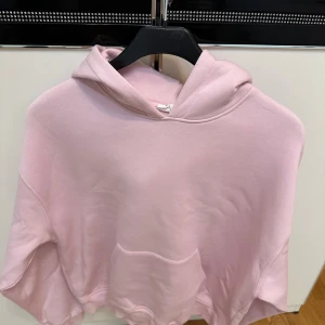 Ljusrosa hoodie med huva - Säljer en ljusrosa hoodie med stor huva och magficka. Tröjan har en loose passform och är tillverkad i mjukt bomullsmaterial. Perfekt för chill dagar och enkel att matcha med jeans eller mjukisbyxor.