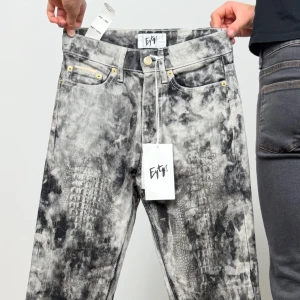 Eytys jeans med gråsvart mönster - Unika jeans från Eytys med gråsvart batikmönster och subtilt reptil-inspirerat tryck. Klassisk femficksmodell med raka ben och guldfärgade nitar. Perfekta för dig som vill sticka ut med en edgy streetstil. Jeansen har fortfarande lapparna kvar 