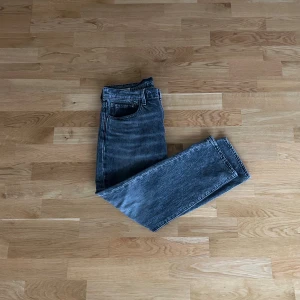 Levi's 502 svarta jeans straight fit - Säljer ett par klassiska Levi's 502 jeans i svart/mörkgrå tvättad denim. Jeansen har rak passform och fem fickor. Perfekta för en avslappnad och tidlös look. Strl: 32/30