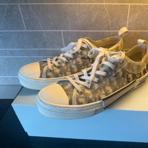 Dior sneakers med monogram och snörning - Dior b23 i storlek 44. Mycket fint skick, men finns litet märke på höger skon på de vita (bild 2). Saknar og men skorna är 100% äkta och går att lösa fler bilder om man skulle vilja göra en LC på dem.