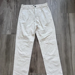 Vita manchesterbyxor från H&M - Snygga vita manchesterbyxor från H&M i regular fit. Byxorna har klassiska fickor fram, bälteshällor och stängs med knapp och dragkedja. Perfekta för dig som gillar en stilren look med lite struktur tack vare manchestertyget.