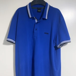 Blå pikétröja från BOSS + Blå shorts från BOSS - Blå pike sett (pike+shorts) från BOSS köptes för några  månader sen. Knappt använts. Endast piké för 700 ( köpt 1059kr). Endast shorts 350 ( köpt 459kr). Fin combination