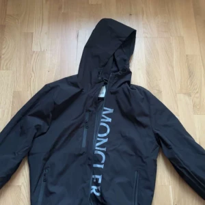 Svart vindjacka från Moncler  - Tja säljer min svarta moncler vindjacka. Det är i storlek L men den passar bättre som storlek M