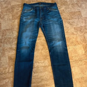 Blå jeans från Lee med raka ben - Säljer ett par klassiska blå jeans från Lee med snygg tvätt och raka ben. Jeansen har fem fickor, normal passform och Lee-lapp bak i midjan. Perfekta för dig som gillar en enkel och stilren look.