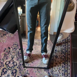 Grågrön replay Anbass slim jeans 33/30 - Snygga mörkgröna byxor från Tiger of Sweden med raka ben och klassisk passform. Byxorna har fem fickor, bälteshällor och är tillverkade i ett mjukt bomullsmaterial med lite stretch. Perfekta för en clean och stilren look. Modellen är 178cm 70kg midja 38 längd 98cm (23)