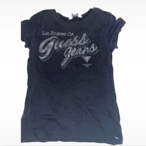 Svart kortärmad t-shirt från Guess  - Tröja från guess!! Jätte söt!! Använde mycket innan men inte längre 💔 funkar i storlek S med. Jag har klippt den kortare, ( se bild 1      