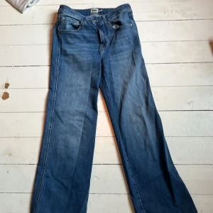 Blå bootcut jeans 157 90's Boot M - Säljer ett par blå jeans från 157 i modellen 90's Boot, storlek M och full längd. Jeansen har klassisk femficksdesign, normal passform och bootcut-ben som ger en snygg siluett. Perfekta för dig som gillar retrovibbar och bekväma jeans. Lite trasiga längst ner på ena benet 