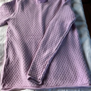 Ljusrosa/lila stickad tröja från Newhouse - Superfin ljusrosa/lila stickad tröja från Newhouse i 100% bomull. Tröjan har ett snyggt strukturerat mönster, rund halsringning och långa ärmar. Perfekt för höstväder