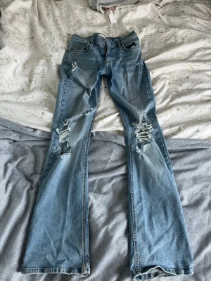 Slitna ljusblå bootcut jeans - Moderna slitna itgirl jeans som man för det mästa bara hitta på Pinterest. Jätte snygga och passar till allt.