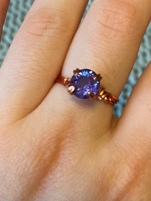 Handgjord ring med koppartråd och lika sten - Ring gjord med koppartråd och en lila skimrande sten. Skriv vid frågor