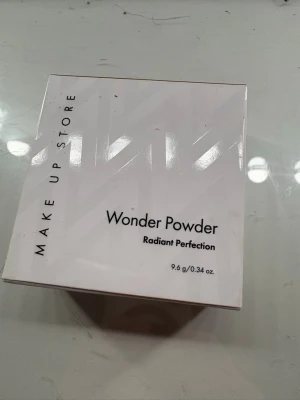 Wonder Powder från Make Up Store - Wonder Powder Radiant Perfection från Make Up Store, 9,6 g. Kommer i en rund, stilren förpackning med spegelblankt lock. Pudret har en varm beige ton och appliceras genom ett nät i dosan för jämn fördelning. Perfekt för en fräsch och strålande finish som även ger ett vackert glow. 