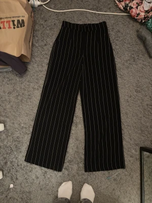 Vida randiga byxor  - Vid byxor med ränder som stängs med en dragkedja på sidan, skick är svårt att sätta exakt då alla har olika åsikter men enligt mig är skicket bra och jag kan inte hitta några skador när jag kollar igenom