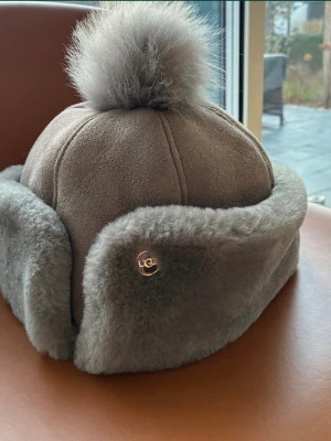 Fårskinnsmössa med från UGG - Säljer en supermjuk och varm fårskinnsmössa från UGG. Mössan är oanvänd.
