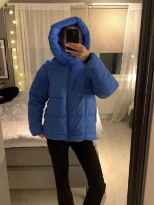 Blå pufferjacka från ONLY, M - Säljer en blå pufferjacka/ vinter jacka  från ONLY i storlek M. Två magneter inuti tyget på höger och vänster sida, som är till för att stänga till. Jackan är storlek M men skulle säga att den passar till S med. Jag är S i vanliga fall och är 172 cm lång och ni ser på bilden hur den sitter i längd osv på mig. Köpt för 500kr