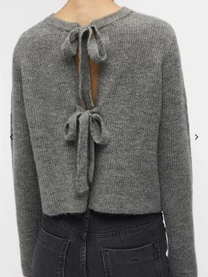 Tröja  - Supersöt grå stickad tröja ifrån objects. Knappt använd, inga defekter:) Funkar både att ha rosetterna bak och fram. Skriv för fler bilder eller frågor☺️ Köpt för 500kr. 