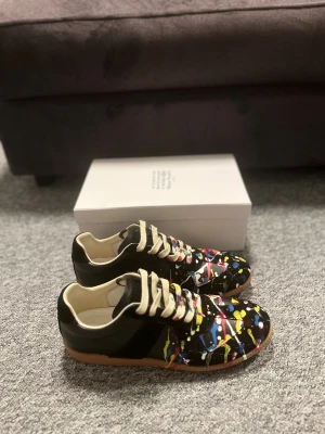 Maison Margiela Paint Splatter - Dessa skor har aldrig varit använda, helt nya. Stilrena och passa för uppkommande säsong. Priset är inte hugget i sten. Skickar samma dag. Box och allt sånt medföljer. Kom gärna med frågor! Skorna är storlek 45
