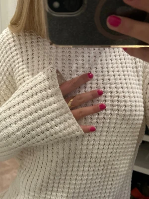 Vit stickad tröja  - Säljer en vit stickad tröja med grov, strukturerad ribb och lång ärm ifrån Filippa K. Tröjan har en avslappnad passform och är perfekt för lager på lager under kyligare dagar. Enkel och stilren design som passar till det mesta. Aldrig använd!