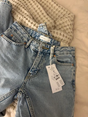 Ljusblå raka jeans från Gina Tricot  - Säljer ett par ljusblå raka jeans från gina tricot med klassisk femficksmodell och bälteshällor. Jeansen har låg  midja.