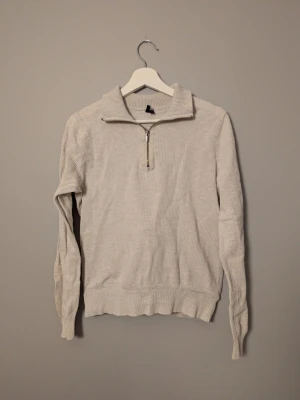 Halvzip från Hampton Rupbublic - Beige stickad tröja från Hampton Republic med ribbad krage och half zip-dragkedja. Tröjan har inga defekter. Priset är inte hugget i sten och det är bara att höra av sig vid frågor och funderingar!