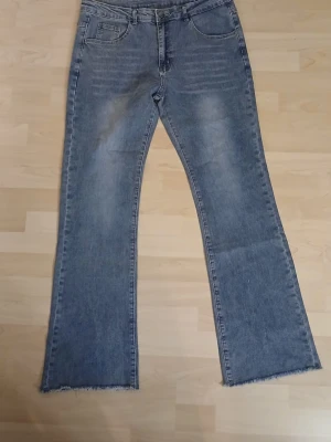 Blå bootcut jeans från Temu rå kant XL - Snygga blå bootcut jeans i storlek XL med rå, fransad kant nertill. Jeansen har klassisk femficksdesign och är tillverkade i en mix av bomull, polyester och lite elastan för extra stretch. Perfekta för dig som gillar en avslappnad och trendig look. Från Temu!