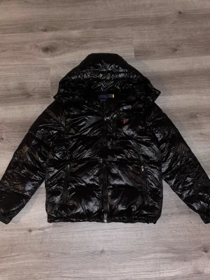 Ralph Lauren Pufferjacka | S | Mycket bra skick - Märke: Ralph Lauren Produkt: Pufferjacka Storlek: S Färg: Blank svart Skick: Mycket bra  Rent och välskött. Inga fläckar, hål eller defekter. Box ingår ej. Se bilder för fullständig skickbild.  Pris är icke förhandlingsbart. Snabb leverans • Snabba svar Fråga gärna om du undrar något