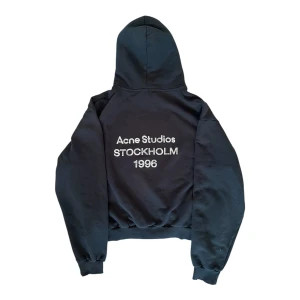 Acne Studios Hoodie – Stockholm 1996 – Svart - Säljer en Acne Studios hoodie i klassisk svart färg, med den ikoniska texten ”Acne Studios Stockholm 1996” tryckt på ryggen. Stilren skandinavisk design med en exklusiv känsla.  Tillverkad i tjock och högkvalitativ bomull med en strukturerad men bekväm passform. Perfekt för vardagsbruk, streetwear-outfits eller en minimalistisk lyxstil.  Skick: Mycket bra (se bilder) Passform: Normal till något croppad / boxig passform (typisk Acne Studios-stil) Färg: Svart Stil: Lyx, minimalistisk, streetwear 