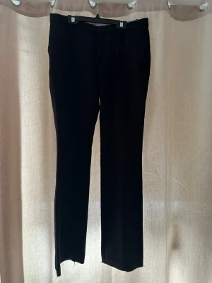 Svarta kostymbyxor från Neo Noir M - Säljer ett par svarta kostymbyxor från Neo Noir i storlek M. Byxorna har raka ben, diskreta fickor och klassisk låg midja. Perfekta till en clean och stilren look. Materialet känns mjukt och följsamt.