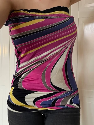 Färgglad mönstrad tubtopp - Säljer en mönstrad tubtopp, perfekt som festtopp. Stretchigt material så mycket passar många. Står XS men jag tycker att den passar M bra.