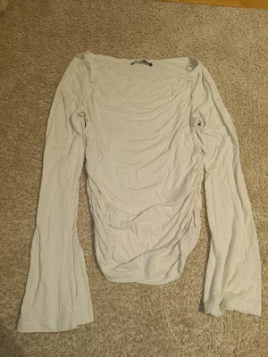 Långärmat tröja  - Tajt långärmad med utsvängda ärmar och dragsko på båda sidorna. Från gina i storlek s. Har knappt använt. 