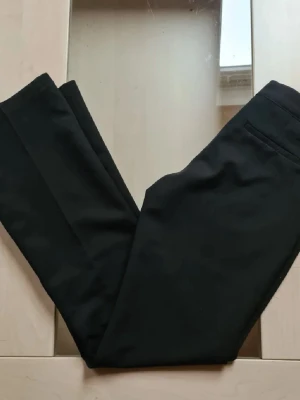 Svarta kostymbyxor med raka ben och låg midja Bikbok Vera - Snygga populära svarta kostymbyxor med raka ben, pressveck och låg midja. Byxorna har midjehällor och sidfickor. Aldrig använda. Långa i benen. 