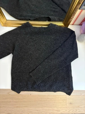  stickad tröja  - Mysig mörkgrå stickad tröja från Vero Moda i enkel och clean design. Tröjan har lång ärm, rund halsringning och ribbade muddar. Perfekt för lager på lager under kyliga dagar.