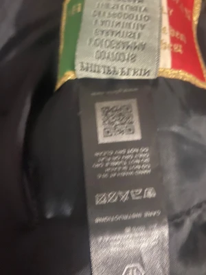 Svart väst från Philipp Plein - Säljer en svart väst från Philipp Plein med ikonisk PP-logga på bröstet och detaljer i guld. Jackan är tillverkad i Italien och har en quiltad design med dragkedja framtill. Perfekt för dig som vill ha en lyxig och stilren look.